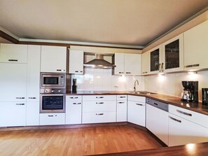 Een oven, een vaatwasser, een broodrooster, eettafels