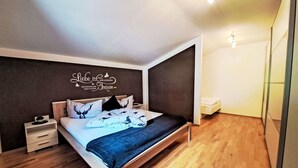 A modern bedroom with a wooden bed, a nightstand, a wall-mounted shelf, and a ceiling light fixture. - Stunning  villa for 8 guests with WIFI, TV, balcony and pets allowed (Ramsau Im Zillertal)