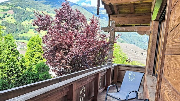 A wooden balcony with a table and chairs, overlooking a mountainous landscape with trees. - Stunning  villa for 8 guests with WIFI, TV, balcony and pets allowed (Ramsau Im Zillertal)