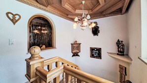 A wooden staircase with a chandelier, a heart-shaped decoration, and a fireplace. - Stunning  villa for 8 guests with WIFI, TV, balcony and pets allowed (Ramsau Im Zillertal)