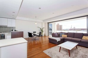 Living area - “Enjoy Fremantle from this spacious 3BR apartment with port views, communal pool & free parking — walk to Rottnest Ferry & Markets.” (Fremantle)