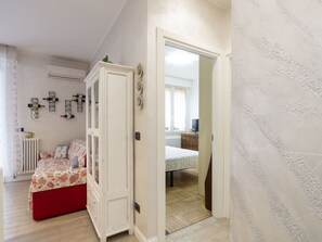 A bedroom with a bed, a wardrobe, a radiator, and wall-mounted decor.