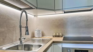 A modern kitchen with a stainless steel sink, a built-in oven, and a compact microwave. - Beautiful apartment in villa for 5 guests with WIFI, A/C, TV, patio and pets allowed (Arzachena)