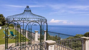 A gazebo with a view of the sea and a distant island.