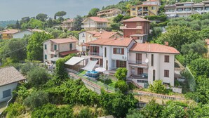 A hillside residential area with terraced houses, some with balconies and satellite dishes.