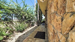 A stone pathway leading to a building with a stone wall and a light fixture. - Wonderful  villa for 6 people with A/C, WIFI and terrace (Augusta)