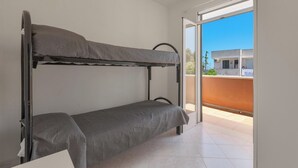 A bunk bed in a room with a view of a building through an open door. - 4128 Villino Giovanna by Barbarhouse (Melendugno)