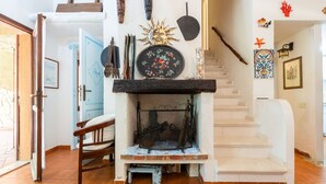A rustic interior with a fireplace, wooden furniture, and decorative items on the walls.