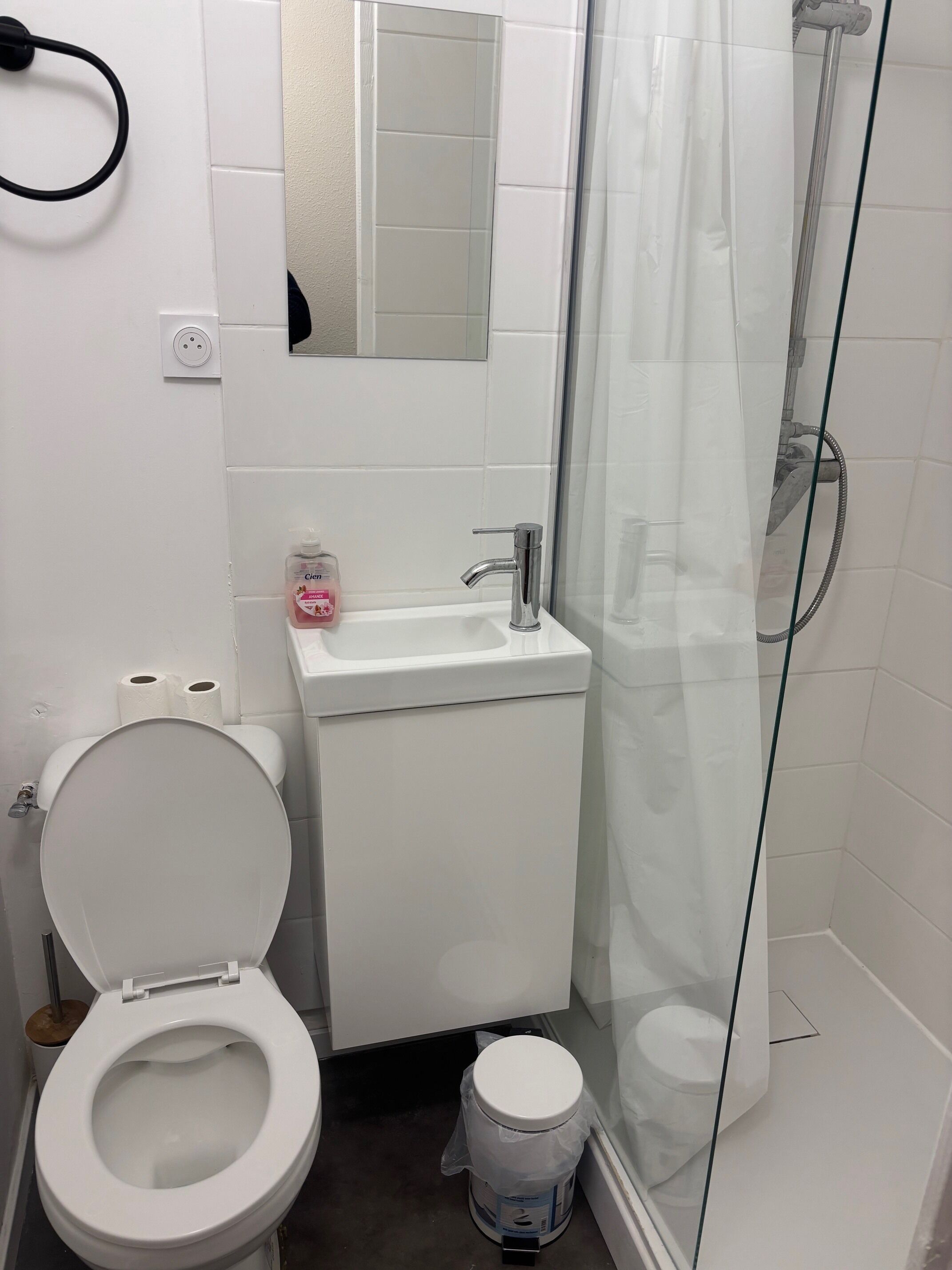 A bathroom with a toilet, sink, and shower.