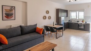 A modern living room with a grey sofa, wooden coffee table, and a dining area with a table and chairs.