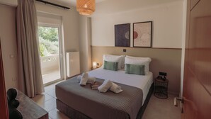 A bedroom with a large bed, a bedside table, a hanging light fixture, and two framed artworks on the wall.