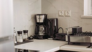 A kitchen with a coffee maker, salt and pepper shakers, and a toaster.