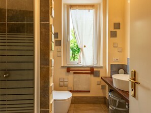 A bathroom with a toilet, sink, and shower area.