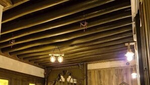 Une chambre avec deux lits, des murs en bois et un plafond en pente avec des poutres apparentes.