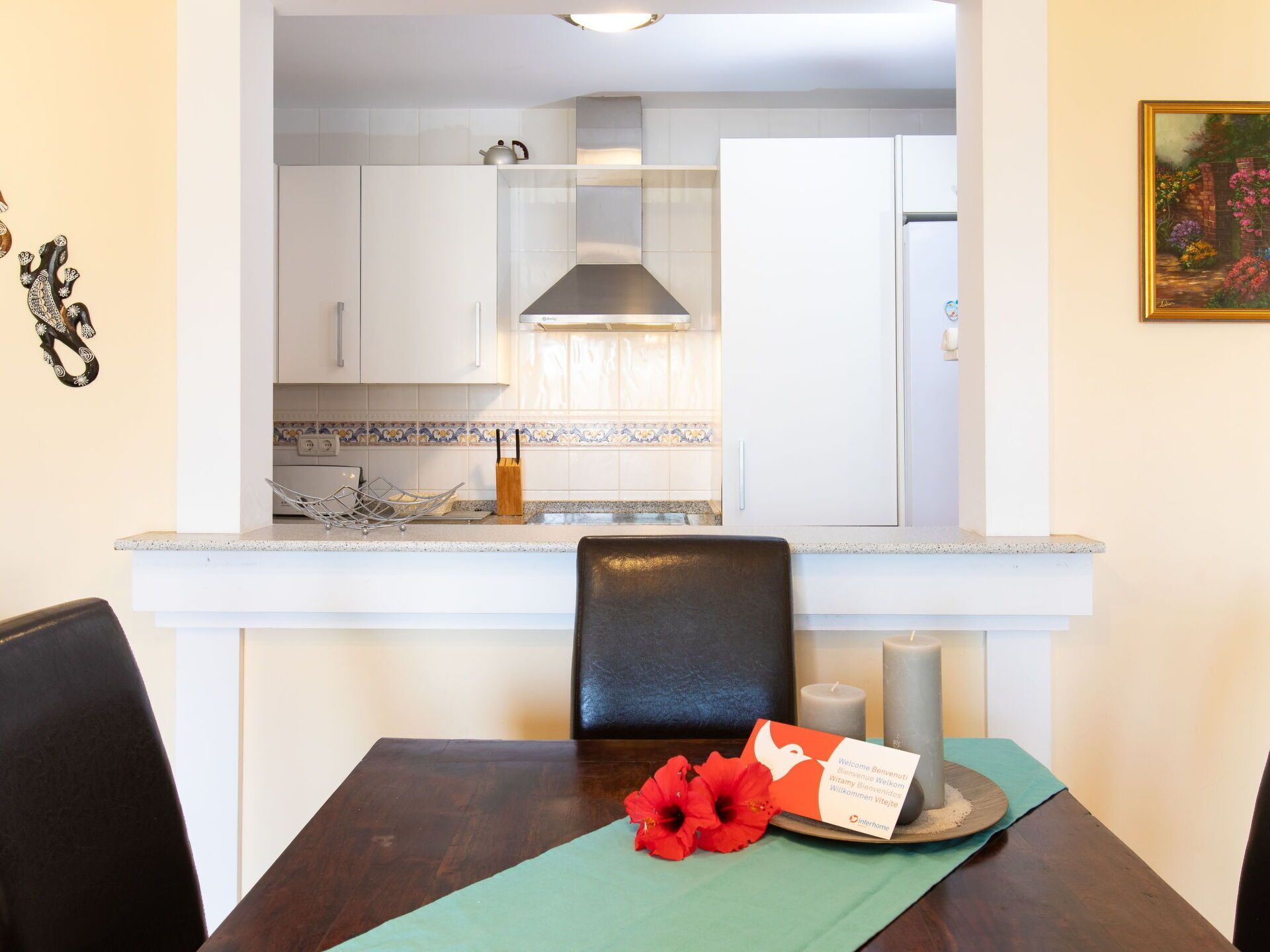 A dining table with a placemat, a red flower, and a card.
