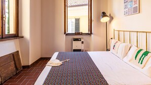 A bedroom with a bed, a window, a radiator, and a wall-mounted lamp. - Beautiful apartment for 3 guests with WIFI and patio (Gravedona)