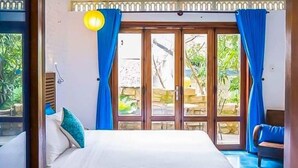 A bedroom with a bed, a window with curtains, and a view of greenery outside. - Loft House 2BR Seaside An Bang Beach (Da Nang)