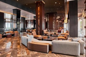 A spacious lobby with modern furniture, a high ceiling, and a large column. - Lusso Sorgun (Manavgat)