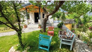 Relax in a serene outdoor setting surrounded by lush greenery and comfortable seating options.