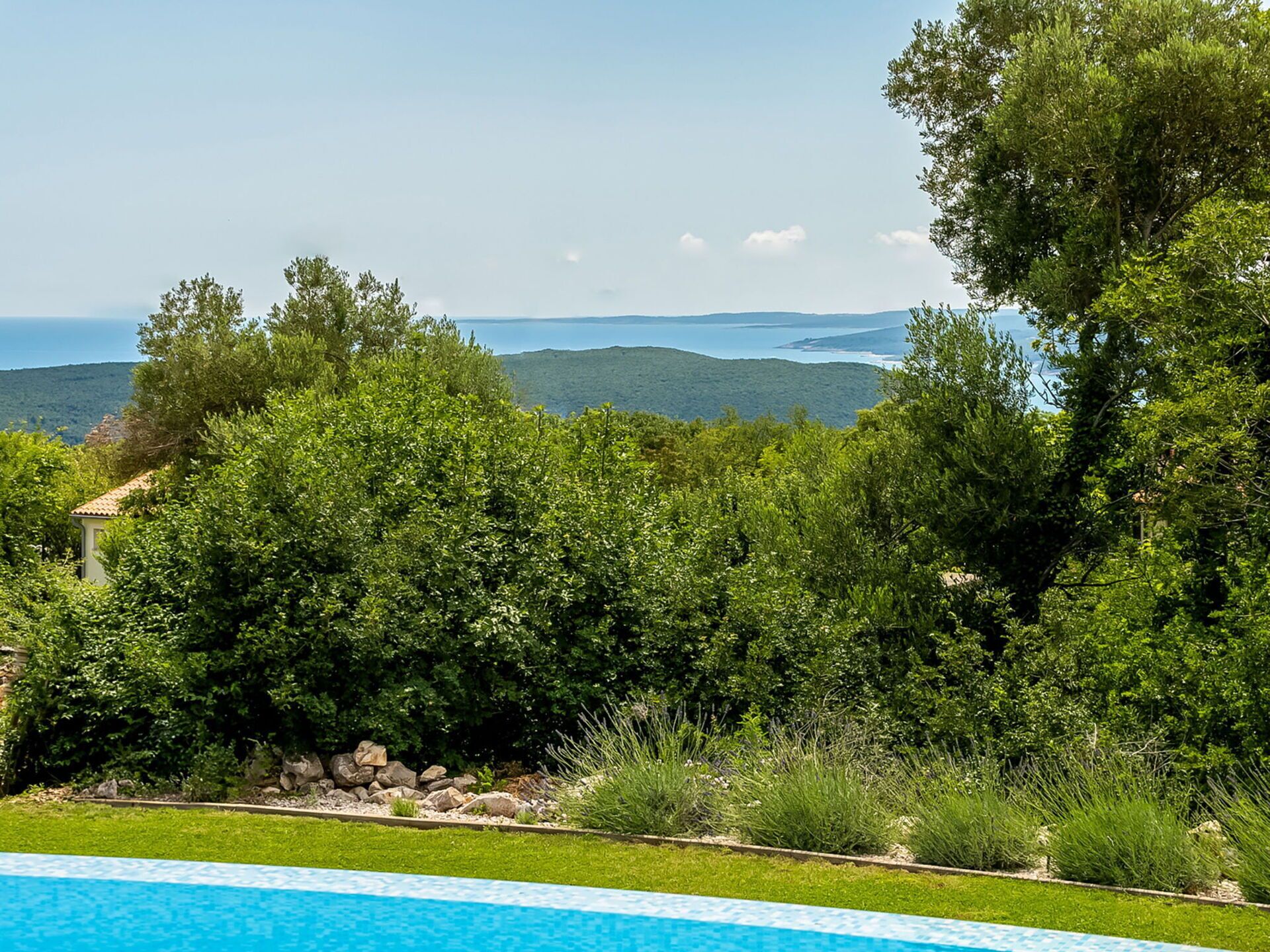 Ein Pool mit Blick auf das Meer und die Hügel.