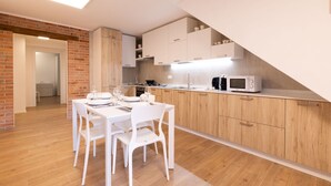 Una cucina moderna con mobili in legno, un tavolo da pranzo bianco e sedie.