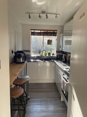 Apartamento | Cocina privada | Frigorífico, microondas, horno y placa de cocina