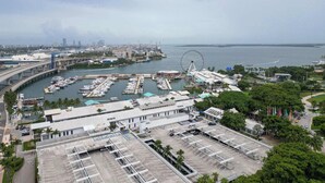 Un port de plaisance avec des bateaux, une grande roue et un parking.