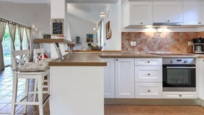 A modern kitchen with white cabinets, a built-in oven, and a breakfast bar. - Beautiful private villa for 5 people with A/C, private pool, WIFI, TV and patio (Umag)