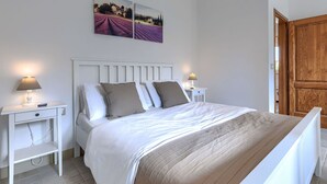 A bedroom with a bed, two bedside tables, a nightstand, a wooden door, and two wall-mounted pictures. - Beautiful private villa for 5 people with A/C, private pool, WIFI, TV and patio (Umag)
