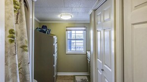 A narrow hallway with a window, a door, and a refrigerator. - Cocodrie Waterfront Fishing Camp - Sportsmans Paradise (Chauvin)