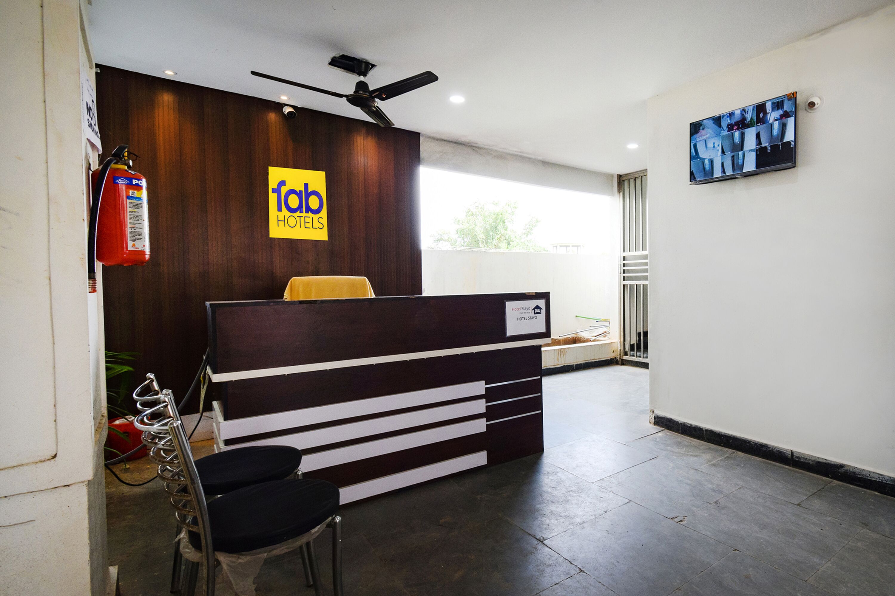 Una reception dal design moderno, un ventilatore a soffitto e un estintore.