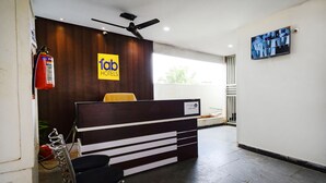 A reception desk with a modern design, a ceiling fan, and a fire extinguisher.