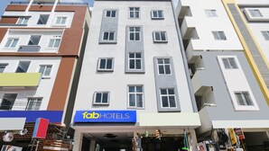 A multi-story hotel with a modern facade, featuring a prominent 'Tab Hotels' sign.