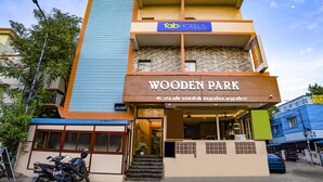 Un edificio de varios pisos con un letrero que dice 'Fab Hotels' y 'Wooden Park'.