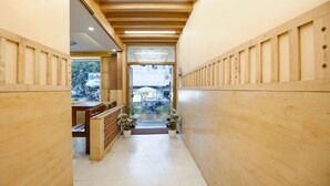 Un pasillo de madera con un banco y plantas en macetas.