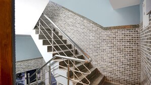 Una escalera con barandilla metálica y azulejos decorativos.