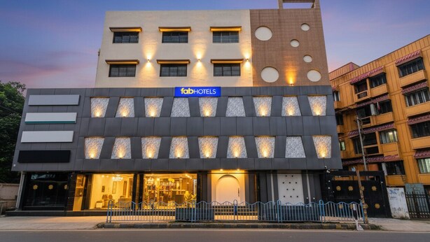 Un bâtiment moderne, orné d'une enseigne « fabHOTELS », avec un rez-de-chaussée doté de grandes fenêtres et une entrée bien visible.