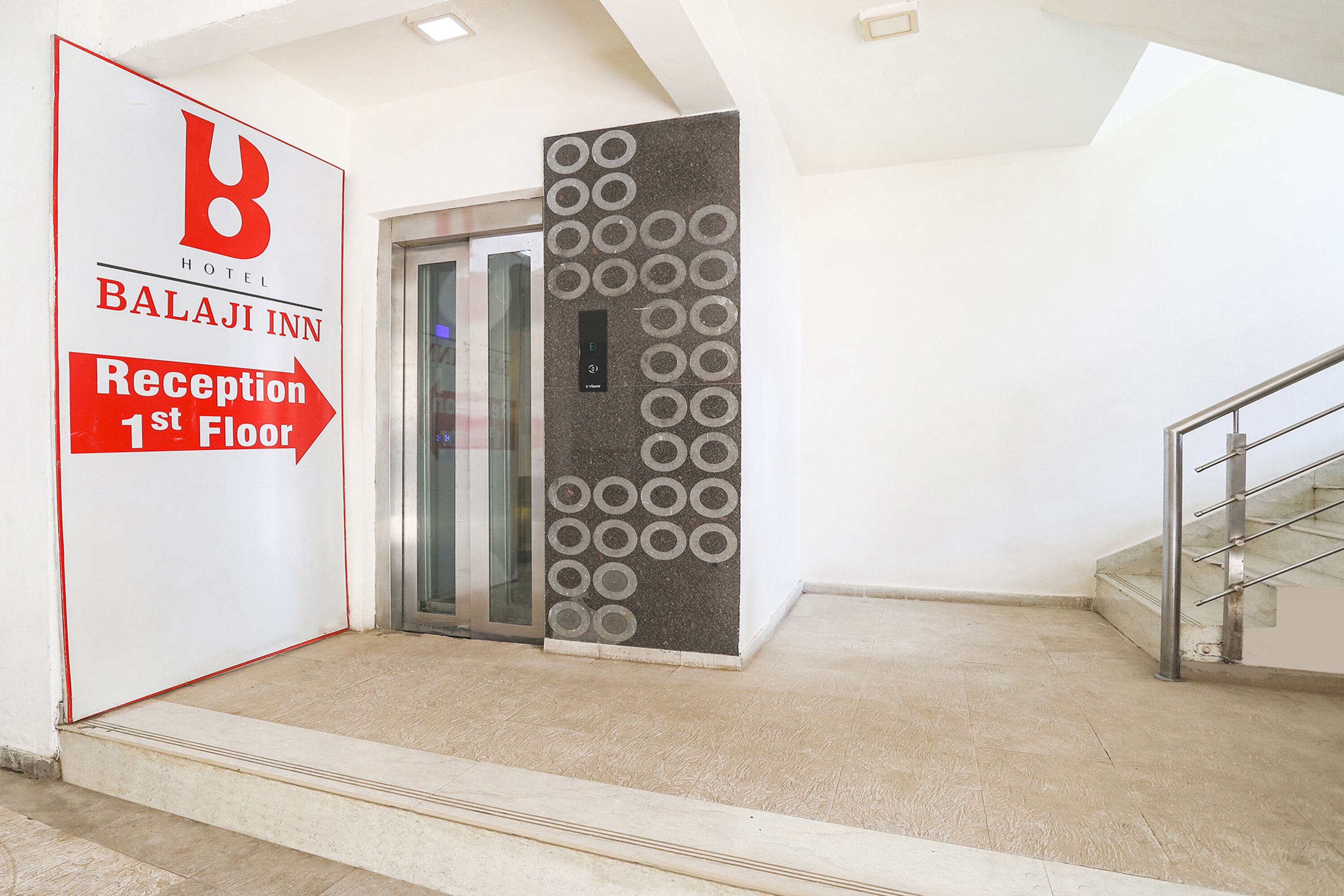 A hotel reception area with a sign indicating the reception is on the first floor.