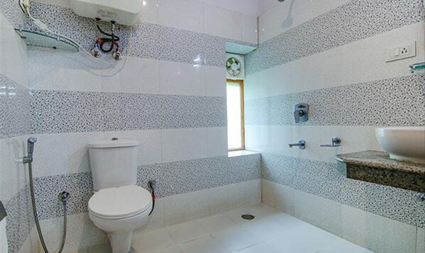 Une salle de bain avec des toilettes, une douche et un lavabo.