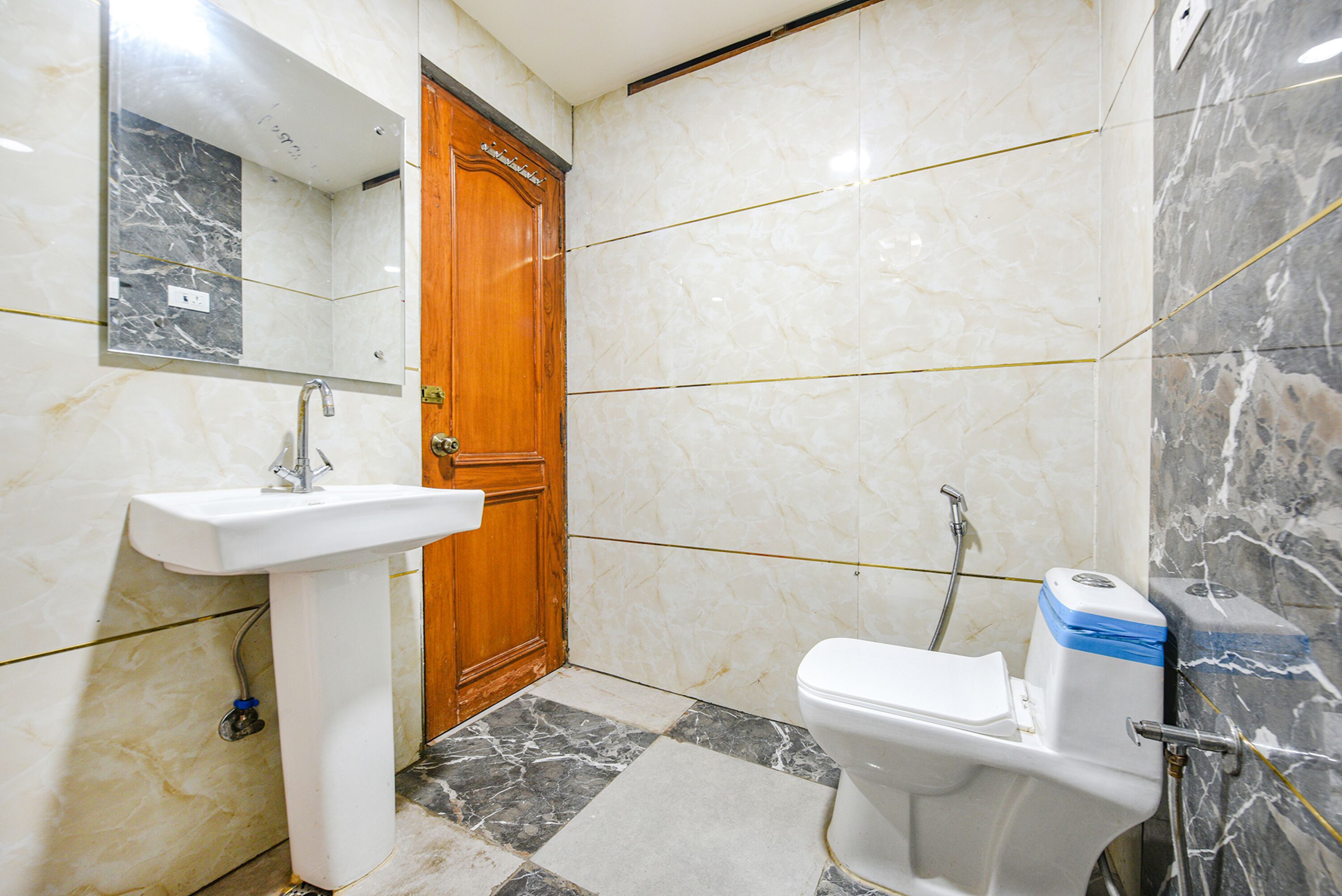 Un baño con lavamanos, inodoro y espejo.