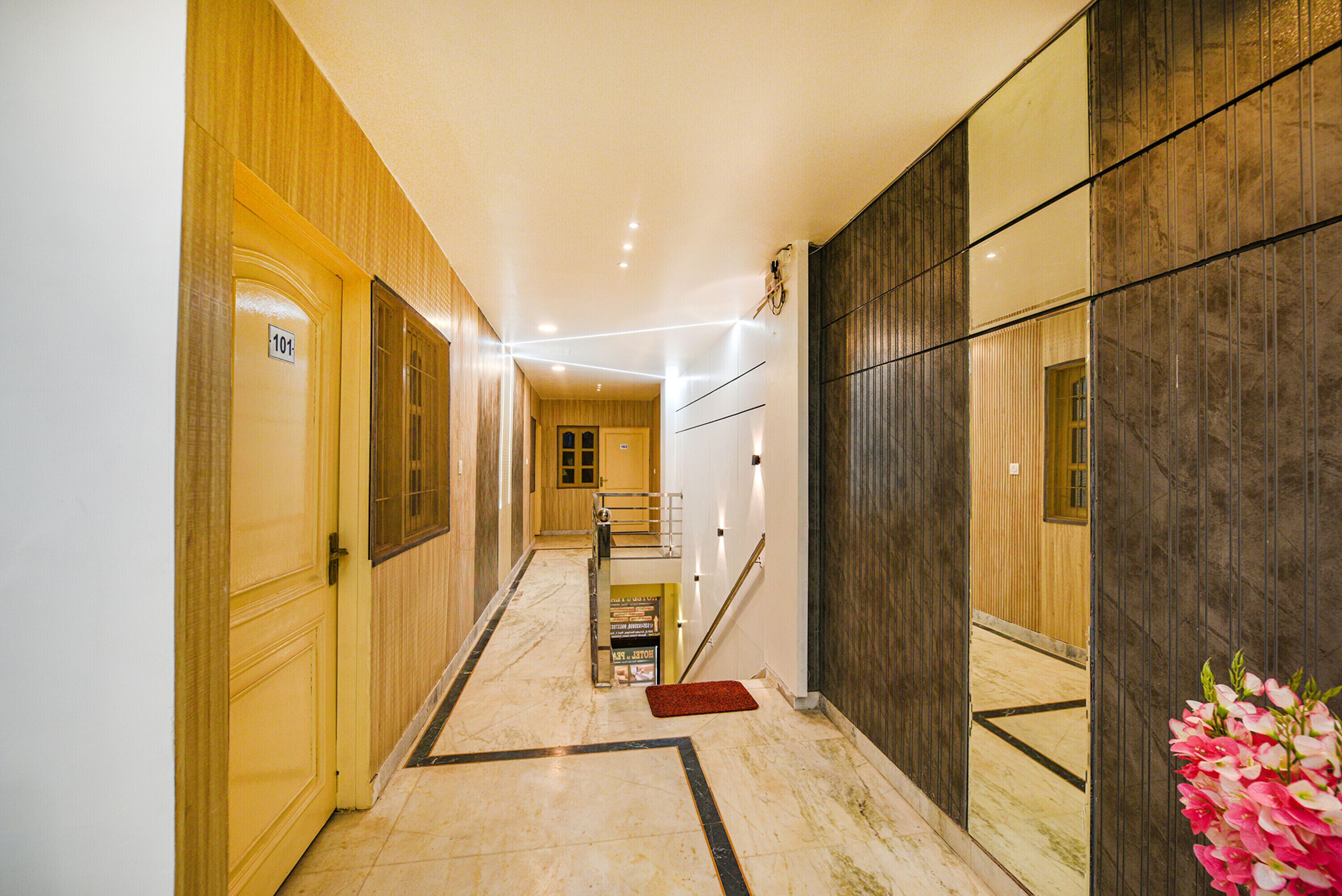 Un couloir avec une porte en bois portant l’inscription « 101 », un escalier et un tapis rouge au bas de l’escalier.