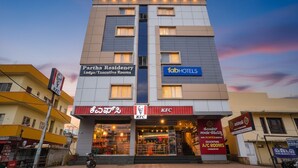 En bygning med flere etager, hvor Partha Residency og KFC er beliggende i stueetagen, og 1abHOTELS findes på anden sal.