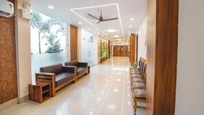 Eine moderne Lobby mit einem Holzbüro, Ledersitzmöbeln und einem Deckenventilator.