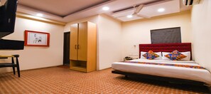 Une chambre à coucher comprenant un lit, une armoire, un bureau et un téléviseur.