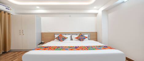 A hotel room with a bed, a wardrobe, and a ceiling light.