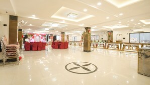 A spacious hotel lobby with a central seating area, a reception desk, and a decorative column. - Fabhotel Royal Carpet (Patna)