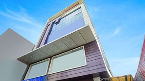 A modern hotel with a prominent 'Tab Hotels' sign, large windows, and a clear sky. - Fabhotel Royal Carpet (Patna)