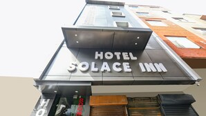 Une enseigne d’hôtel portant le nom « Hotel Solace Inn ».