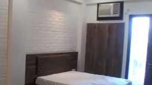 Une chambre à coucher avec un lit en bois, des murs blancs et une armoire en bois.