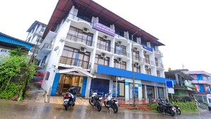 A multi-story building with a sign for Hotel Rui Kings Palace. - Fabhotel Raj (Madikeri)